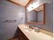 Cozy powder room features a single sink vanity with a framed mirror and dark fixtures at 940 Brittany Ct # 23, Gastonia, NC 28056