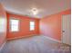 This bedroom features neutral carpeting, peach-painted walls, and two double-hung windows at 940 Brittany Ct # 23, Gastonia, NC 28056