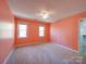 This bedroom features neutral carpeting, peach-painted walls, and two double-hung windows at 940 Brittany Ct # 23, Gastonia, NC 28056