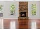 Cozy living room with a stone fireplace, hardwood floors, and windows with backyard views at 9506 Minnie Lemmond Ln # 170, Mint Hill, NC 28227