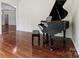 Bright living room featuring a grand piano and gleaming hardwood floors at 9506 Minnie Lemmond Ln # 170, Mint Hill, NC 28227