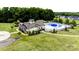Aerial view of community pool and clubhouse surrounded by lush landscaping, playground, and neighborhood homes at 9506 Minnie Lemmond Ln # 170, Mint Hill, NC 28227