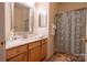 Charming bathroom with a single sink vanity and a shower with patterned curtain at 9820 Janeiro Dr, Huntersville, NC 28078