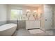 Bright bathroom featuring a free-standing tub and double sink vanity at 9820 Janeiro Dr, Huntersville, NC 28078