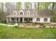 Charming home featuring a well-manicured lawn, a welcoming front porch with rocking chairs, and beautiful landscaping at 9820 Janeiro Dr, Huntersville, NC 28078