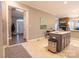 Kitchen with stainless island, tile floors and backsplash, with adjacent view to the living room and front door at 9820 Janeiro Dr, Huntersville, NC 28078