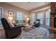 Inviting living room with plush seating, a stone fireplace, and large windows overlooking the outdoors at 9820 Janeiro Dr, Huntersville, NC 28078