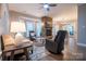 Cozy living room with a stone fireplace, comfortable seating, and ample natural light at 9820 Janeiro Dr, Huntersville, NC 28078