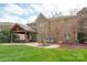 Expansive backyard features a brick home with a covered patio and outdoor dining area at 11308 Wheat Ridge Rd, Charlotte, NC 28277
