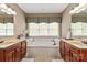 Spacious bathroom features double sinks, large soaking tub and window, tile floors and neutral paint at 11308 Wheat Ridge Rd, Charlotte, NC 28277
