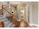 Hallway view features hardwood flooring, staircase, and a glimpse into a powder room at 11308 Wheat Ridge Rd, Charlotte, NC 28277