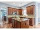 Well-lit kitchen with wood cabinets, a functional island, and updated appliances at 11308 Wheat Ridge Rd, Charlotte, NC 28277