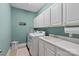 Laundry room with lots of storage, utility sink, newer washer and dryer, and teal walls at 11308 Wheat Ridge Rd, Charlotte, NC 28277
