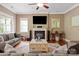 Bright living room featuring a fireplace, large windows, and a ceiling fan at 11308 Wheat Ridge Rd, Charlotte, NC 28277
