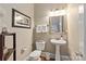 Cozy powder room with a pedestal sink, decorative mirror, and convenient layout at 11308 Wheat Ridge Rd, Charlotte, NC 28277