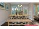 Eat-in kitchen features a long wooden table with bench seating and a view to the outdoor living space at 122 Fordingbridge Ln, Mooresville, NC 28115