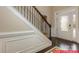 Welcoming entryway featuring dark wood floors, white wainscoting, and a staircase with decorative iron railings at 122 Fordingbridge Ln, Mooresville, NC 28115
