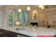 Bright kitchen island with granite counters and stainless steel sink with seating, fireplace, and modern fixtures at 122 Fordingbridge Ln, Mooresville, NC 28115