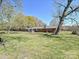 A sprawling backyard with mature trees and a glimpse of the brick home offers a serene outdoor setting at 12300 Eva St, Matthews, NC 28105