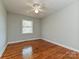 This cozy bedroom features hardwood floors, neutral paint, and a ceiling fan with overhead lighting at 12300 Eva St, Matthews, NC 28105
