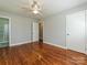 This bedroom has wood floors, neutral walls, base molding, a ceiling fan, and a bathroom at 12300 Eva St, Matthews, NC 28105