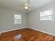 This bedroom has wood floors, neutral walls, base molding, a ceiling fan, and two windows at 12300 Eva St, Matthews, NC 28105