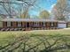 Charming brick home with black shutters and manicured lawn, featuring an attached garage and inviting entrance at 12300 Eva St, Matthews, NC 28105