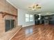 Open living area features a brick fireplace, modern ceiling fan, and seamless flow into an updated kitchen at 12300 Eva St, Matthews, NC 28105