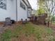 Grassy backyard with a wooden deck, lawn chairs and mature trees at 12708 Hollyhock Ln, Huntersville, NC 28078