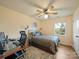 Comfortable bedroom with desk, chair, ceiling fan, natural light, and soothing color palette at 12708 Hollyhock Ln, Huntersville, NC 28078