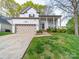 Traditional home featuring a manicured lawn, a beige garage door, and a charming front porch at 12708 Hollyhock Ln, Huntersville, NC 28078