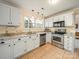 Kitchen with white cabinetry, stainless steel appliances, and granite countertops, creating a bright and functional space at 12708 Hollyhock Ln, Huntersville, NC 28078