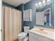 Bathroom with blue walls, a shower with curtain, a single vanity sink, and a toilet at 12804 Lismorre Castle Ct, Charlotte, NC 28273