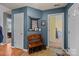 Inviting foyer with a wooden bench, storage, and blue accent wall at 12804 Lismorre Castle Ct, Charlotte, NC 28273