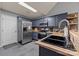 Contemporary kitchen with stainless steel appliances, dark blue cabinets, and a stone backsplash at 12804 Lismorre Castle Ct, Charlotte, NC 28273