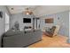 Cozy living room with a gray sectional couch and ceiling fan above on beautiful hardwood floors at 12804 Lismorre Castle Ct, Charlotte, NC 28273