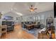Bright living room featuring hardwood floors, a ceiling fan, a comfortable sectional couch, and a large window at 12804 Lismorre Castle Ct, Charlotte, NC 28273
