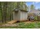 This property features a functional outbuilding with a ramp and a charming dog house, set amidst a wooded backyard at 12804 Lismorre Castle Ct, Charlotte, NC 28273