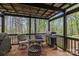 Covered patio area with seating, grill, and wooded backyard view at 12804 Lismorre Castle Ct, Charlotte, NC 28273