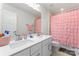 Bathroom with double sink vanity, modern fixtures, and pink shower curtain at 1409 Augustus Beamon Dr, Indian Trail, NC 28079