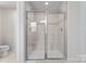 Bathroom featuring frameless glass shower with tile surround, a built in seat, and neutral tile flooring at 1409 Augustus Beamon Dr, Indian Trail, NC 28079