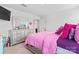 Bright bedroom featuring a playful pink and purple color scheme, a dresser, and ample natural light at 1409 Augustus Beamon Dr, Indian Trail, NC 28079