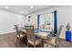 Bright dining room features a wooden table, seating for six, and a window with blue curtains at 1409 Augustus Beamon Dr, Indian Trail, NC 28079