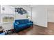 Bright living room boasts a blue sofa, decorative pillows, and sports-themed wall art at 1409 Augustus Beamon Dr, Indian Trail, NC 28079