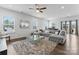 Spacious living room features a large grey sectional sofa, a glass coffee table, and ample natural light at 1409 Augustus Beamon Dr, Indian Trail, NC 28079