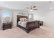 Spacious bedroom featuring elegant furniture, plush bedding, ceiling fan, and lots of natural light at 1409 Augustus Beamon Dr, Indian Trail, NC 28079