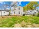 Landscaped backyard with grass, foliage, and a view of the home's white exterior walls at 1409 Effingham Rd, Charlotte, NC 28208