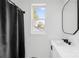 Bright bathroom boasts modern fixtures, shower with dark curtain, and a window at 1409 Effingham Rd, Charlotte, NC 28208