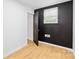 Bedroom with black accent wall, window, and open door showcasing its modern design at 1409 Effingham Rd, Charlotte, NC 28208