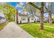Classic home features a green lawn, a driveway leading to the side of the house, and mature trees at 1409 Effingham Rd, Charlotte, NC 28208